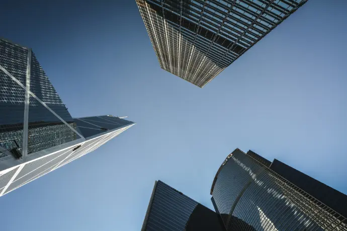 looking up at two skyscrapers in a city